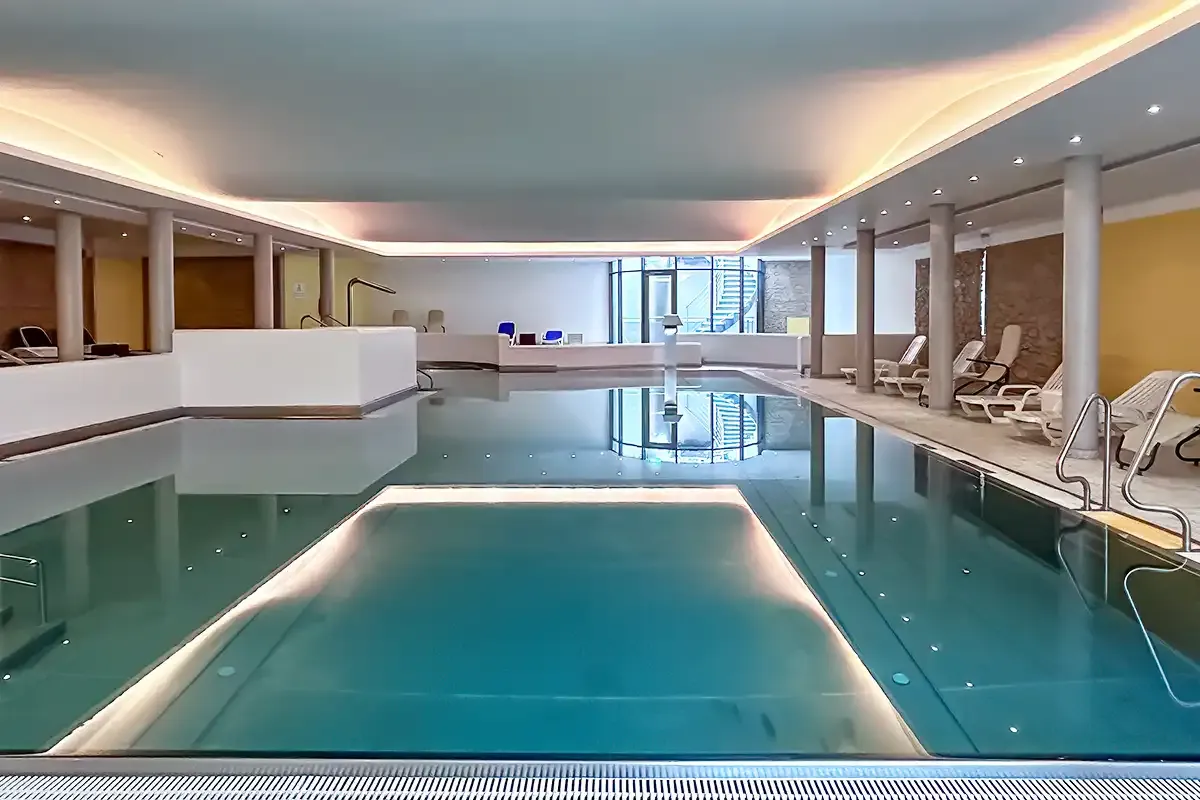 Poolbereich mit angenehmer Beleuchtung und Liegemöglichkeiten zum erholen im Berghotel Hammersbach.