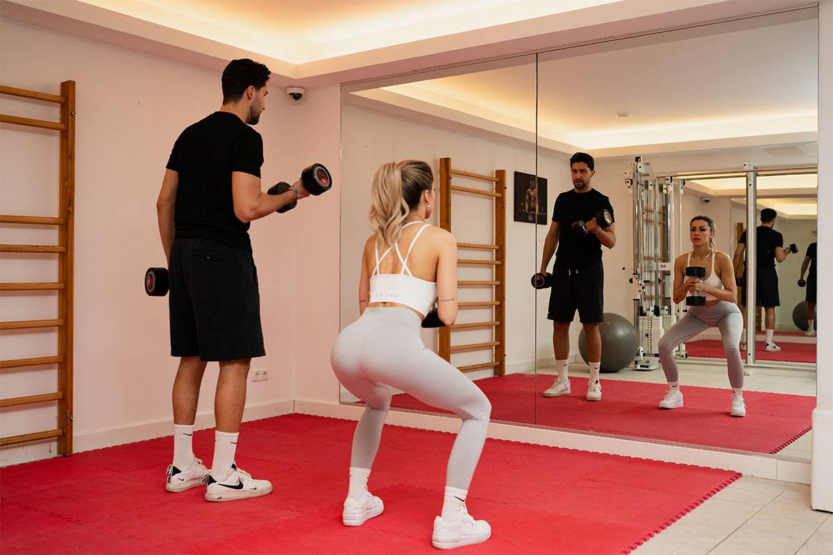 Zwei Personen trainieren mit Handeln im Freihantelbereich im Berghotel Hammersbach.