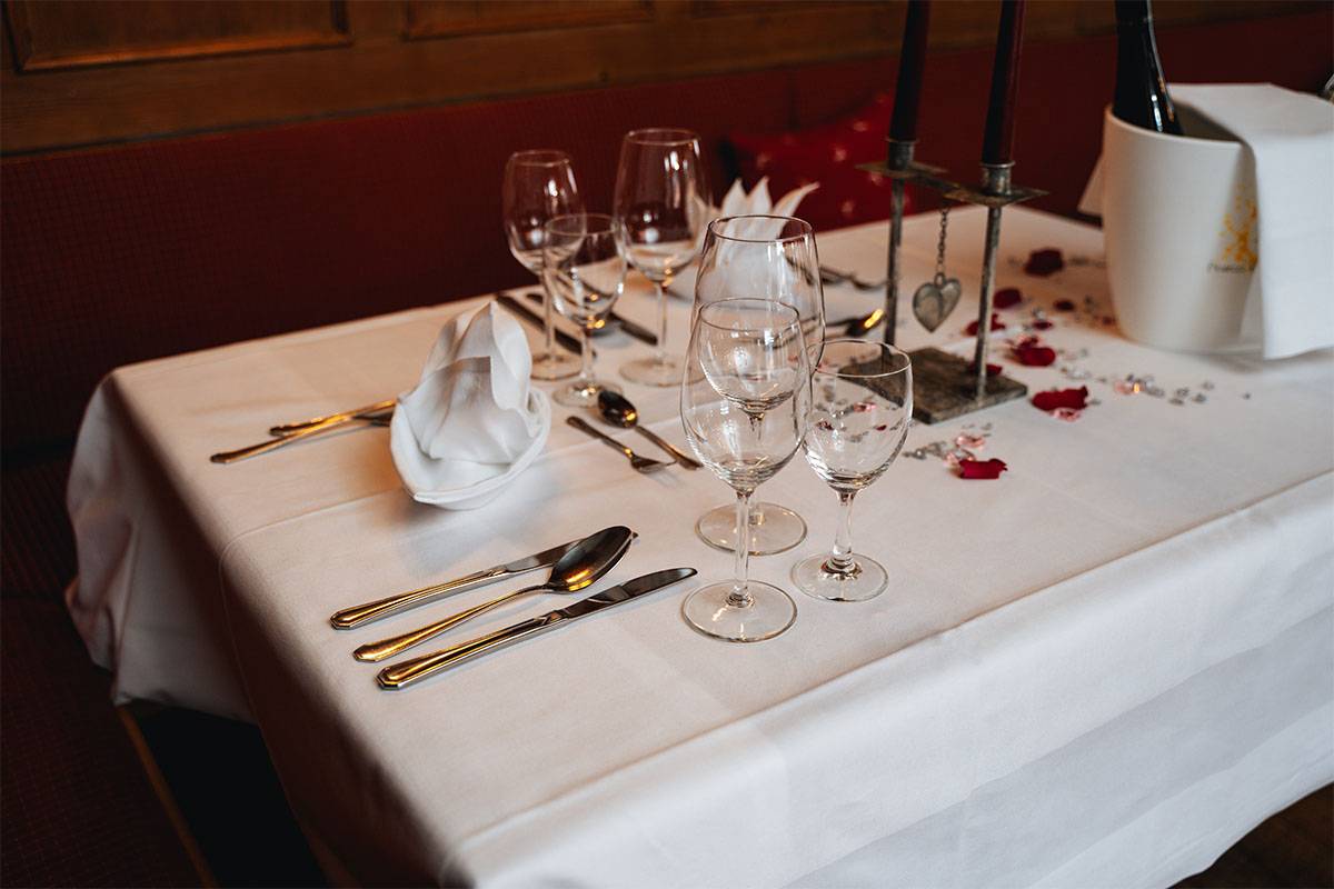 Eingedeckter Tisch mit Blumen und Kerzen für ein romantisches Essen zu zweit im Berghotel Hammersbach.