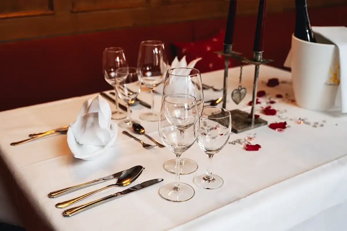 Eingedeckter Tisch mit Kerzen und Blumen für ein romantisches Abendessen im Berghotel Hammersbach.