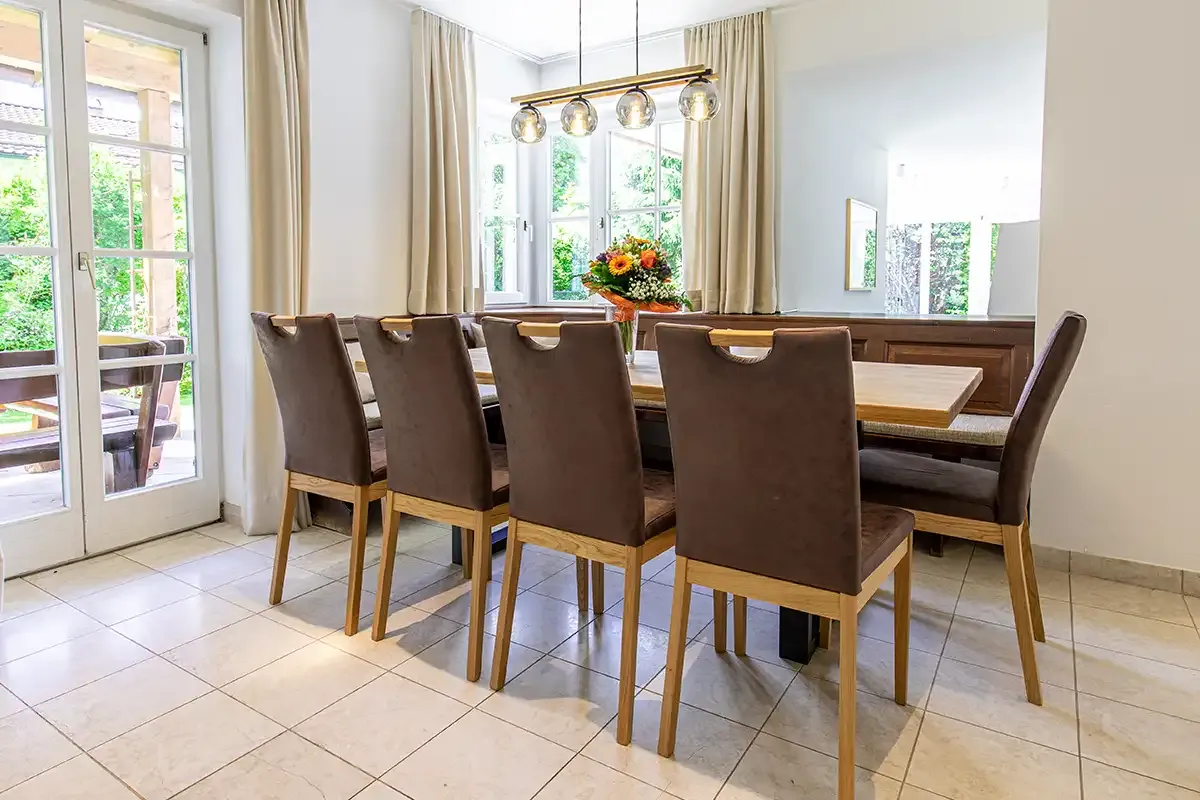 Essbereich im Chalet mit großem Holztisch, Sitzecke an der Wand und fünf weiteren gemütlichen Stühlen.