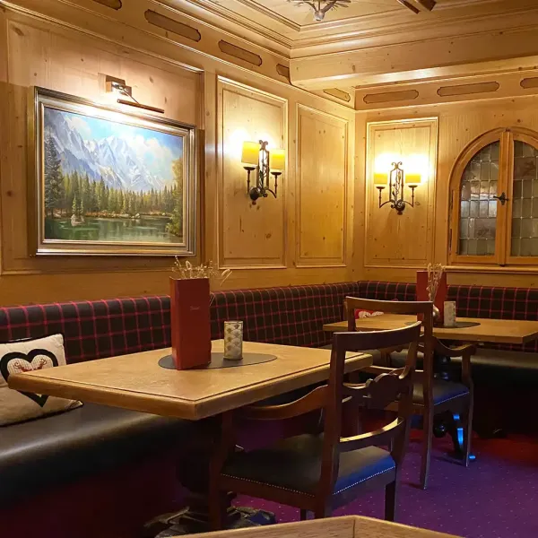 Tischecke in der Kaminbar des Berghotels Hammersbach im bayerischen Stil mit Holzvertäfelungen.