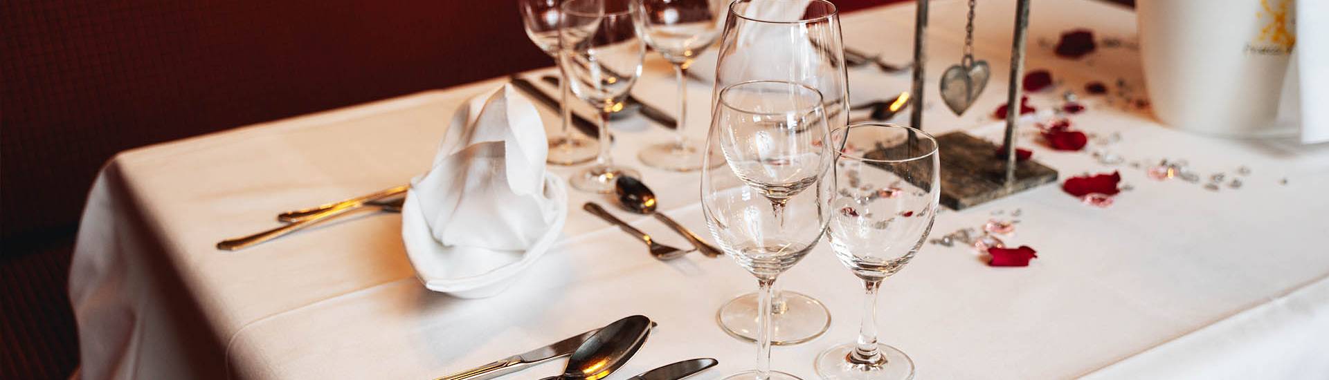 Eingedeckter Tisch mit Kerzen und Blumen für ein romantisches Abendessen im Berghotel Hammersbach.