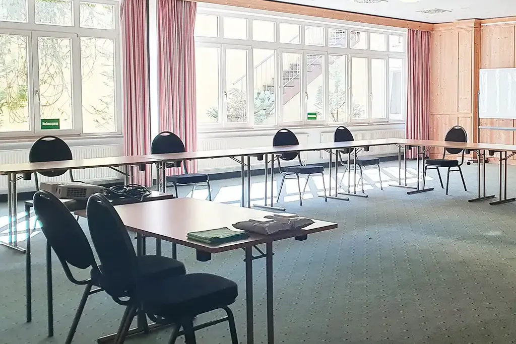 Großer und lichtdurchfluteter Tagungsraum im Berghotel Hammersbach mit Tischreihen und Stühlen.