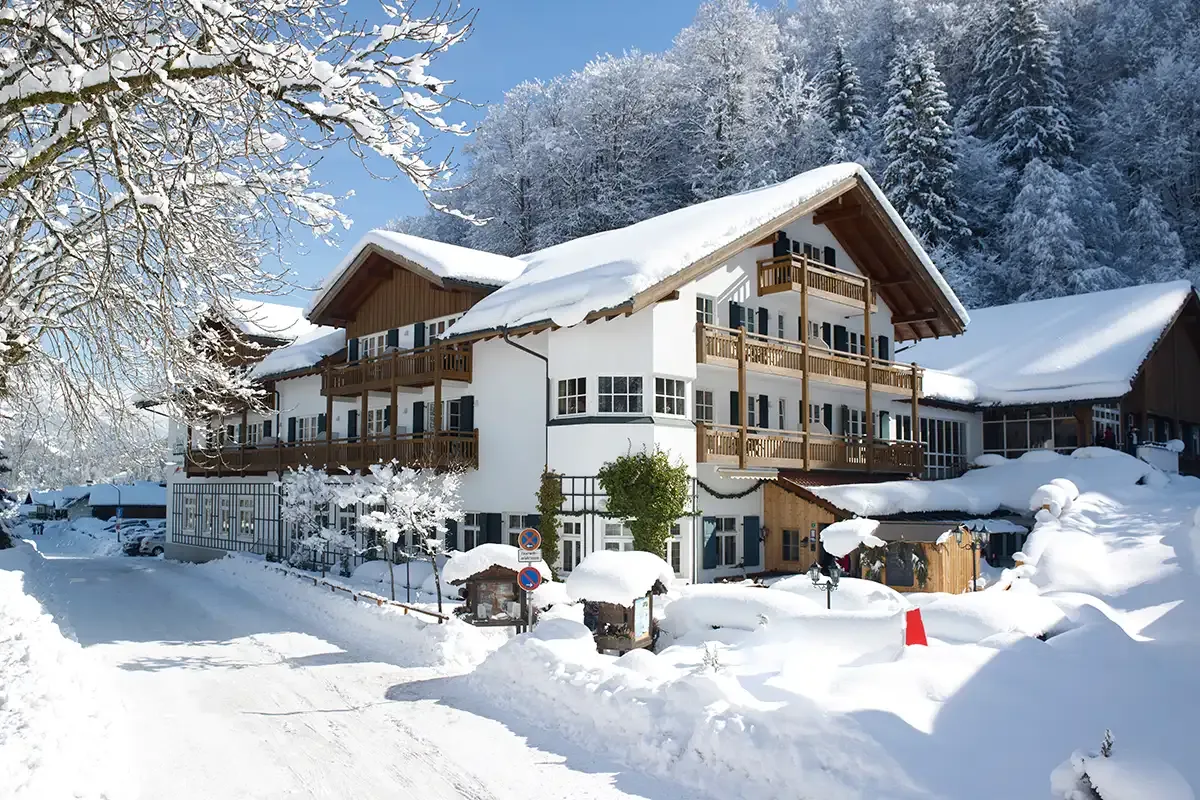 Verschneites Berghotel Hammersbach mit bayerischer Fassade und Holzgeländern.