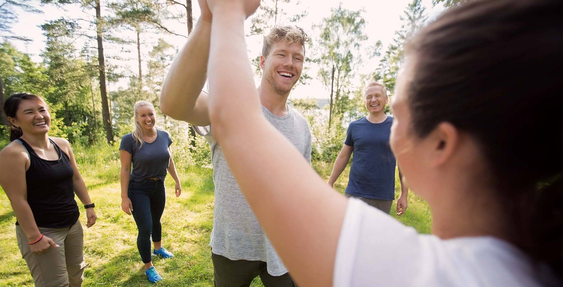 In der Mitte befindet sich ein Mann, der mit einer Frau abklatscht.