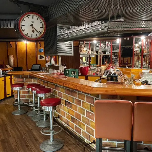 Die Theke der Bar Endstation im Berghotel Hammersbach erstrahlt im Stil einer historischen Bahnstation.