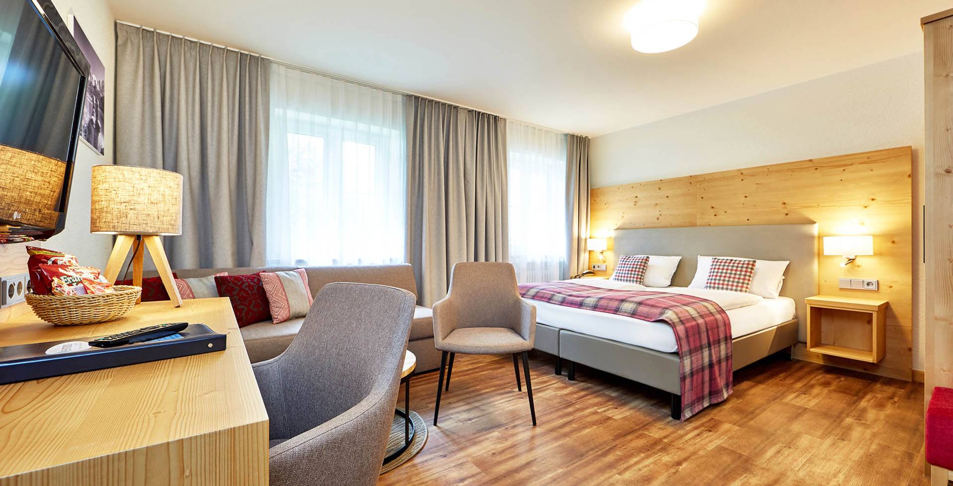 Großes Familienzimmer im Berghotel Hammersbach mit moderner Ausstattung und Schlafsofa für viel Platz.