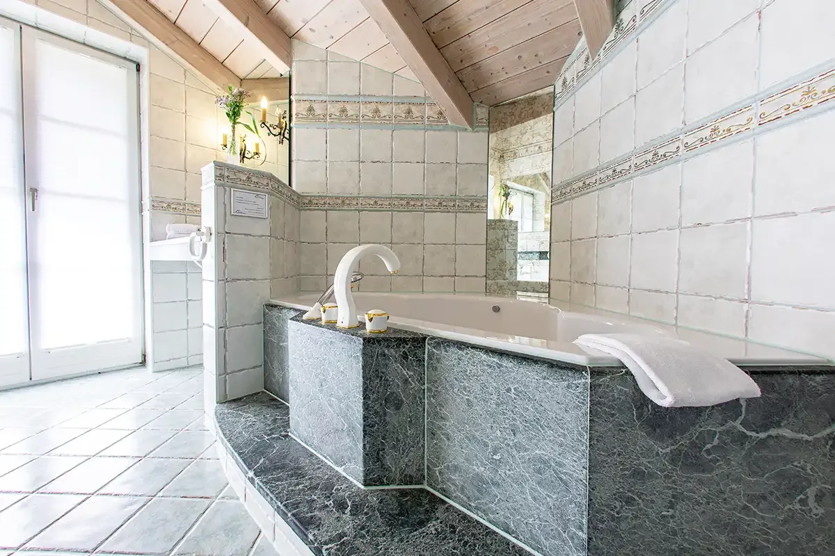 Luxuriöses Badezimmer mit großer, marmorierter Eckbadewanne und viel Platz zum Entspannen im Chalet.